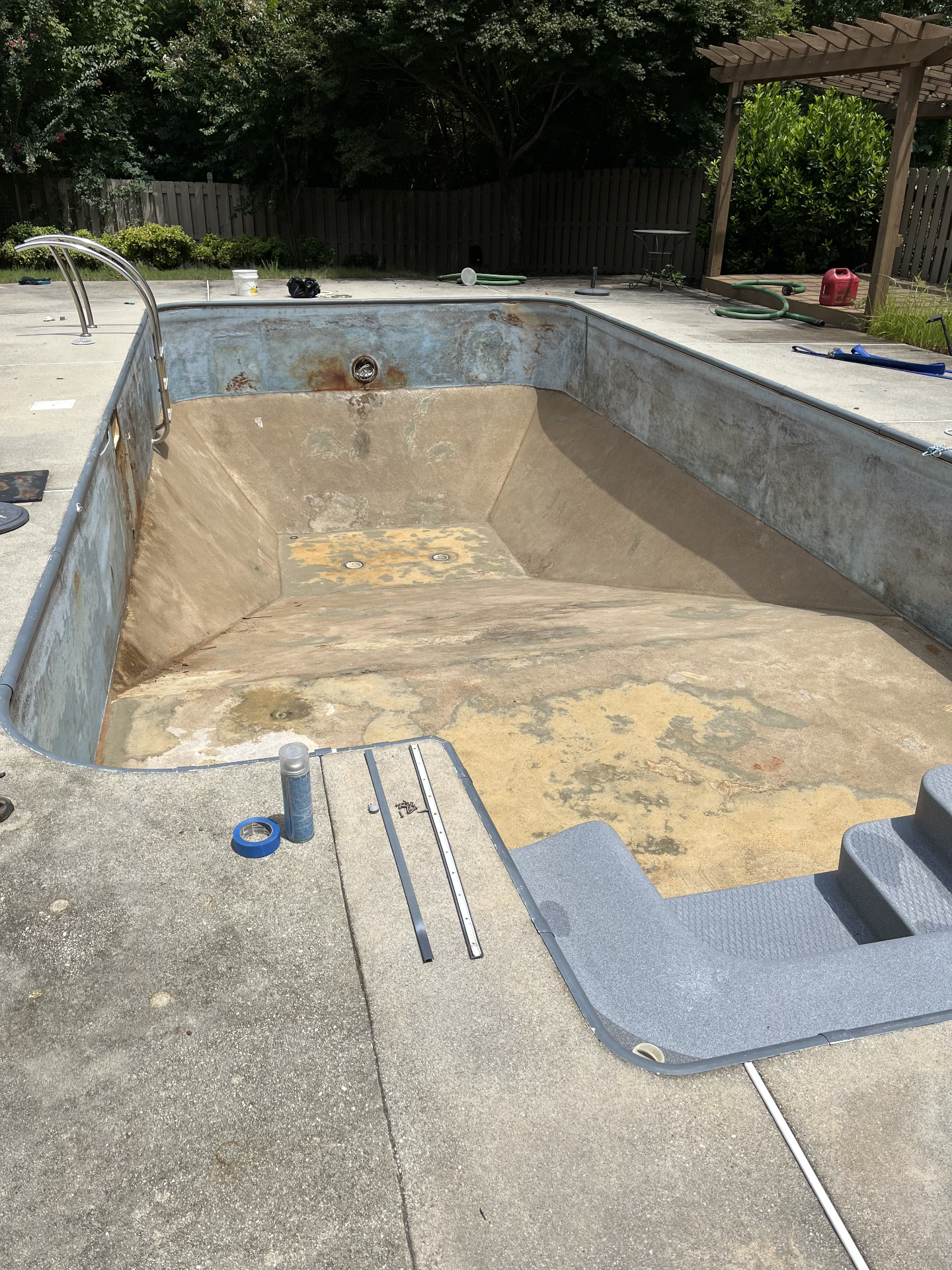 Before swimming pool liner replacement in Winder GA — worn, stained old vinyl liner in an in-ground pool