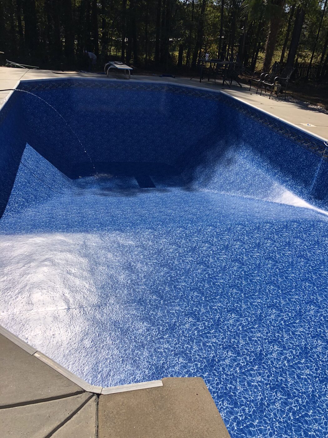 The same pool filling with water after a new blue vinyl liner installation